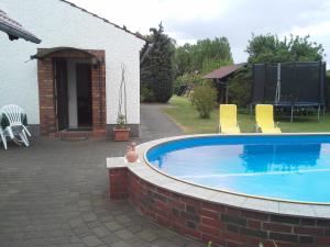 a swimming pool with chairs and a house at Familie Drescher in Radensdorf