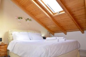 a bedroom with a large white bed with a skylight at The Wooden Nest Arachova in Arachova