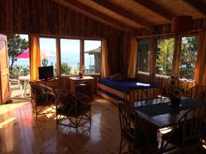a living room with a bed and a table and chairs at Cabañas Campomar in Pelluhue
