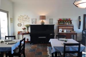a dining room with two tables and a piano at Golden Key Guesthouse in Vredenburg