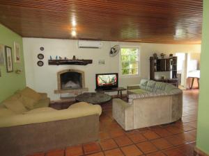 uma sala de estar com dois sofás e uma lareira em Chacara Samambaia em Piracicaba