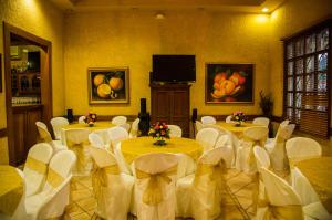 Sala de conferencias con mesas y sillas y TV de pantalla plana en Hotel Cafe en Jinotega