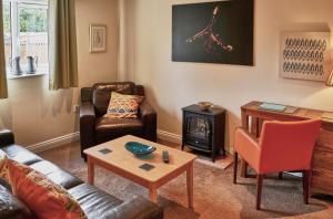 a living room with a couch and a fire place at Farthing Cottage in Norwich