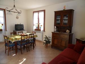 uma sala de estar com uma mesa e cadeiras e uma televisão em Podere San Pierino em Montelupo Fiorentino