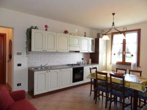 eine Küche mit weißen Schränken und einem Tisch mit Stühlen in der Unterkunft Podere San Pierino in Montelupo Fiorentino