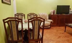 a dining room with three chairs and a table and a television at Apartment MA 2 , 3 rd floor in Banja Luka