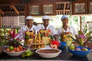 three chefs standing in front of a table with fruit at La Kuka Hotel - Nuquí in Nuquí