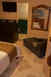 a hotel room with a bed and a tub and a mirror at Motel Piramides De Cristal in Bogotá