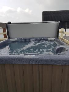 a hot tub with a cover on top of it at Bunny Meadows Holiday Farmhouse near Carmarthen & Pembrokeshire in Carmarthen