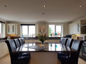 a kitchen with a dining room table and chairs at Bunny Meadows Holiday Farmhouse near Carmarthen & Pembrokeshire in Carmarthen