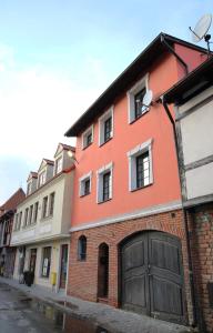 un edificio naranja con garaje en una calle en Willa BROWAR pokoje gościnne, en Starogard Gdański