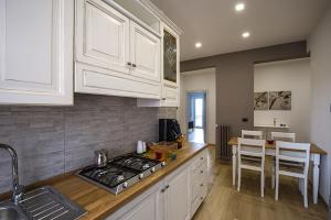 a kitchen with white cabinets and a stove top oven at Casa Angela in Campobasso