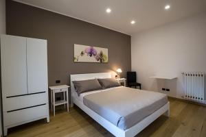 a bedroom with a white bed and a white dresser at Casa Angela in Campobasso