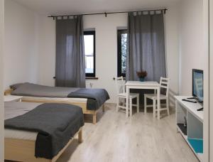 1 Schlafzimmer mit 2 Betten und einem Schreibtisch mit einem Computer in der Unterkunft Willa BROWAR pokoje gościnne in Starogard Gdański