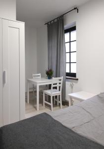 a bedroom with a table and chairs and a window at Willa BROWAR pokoje gościnne w centrum miasta na starówce, Self check in 24H, FV, TV Smart, Darmowe Wi-Fi, Parking, W sąsiedztwie restauracji i kawiarni, Usługi escort zakazane in Starogard Gdański