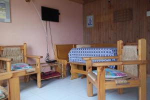 a room with two wooden chairs and a table at Cabañas Los Tamarugos in Pichidangui
