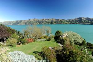 a view of a lake with mountains in the background at Mumfords in Akaroa