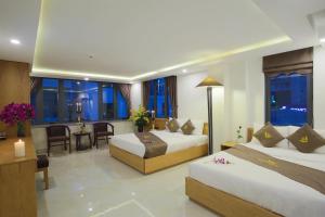 ein Hotelzimmer mit 2 Betten und einem Tisch in der Unterkunft Trang Ngan Hotel by THG in Đà Nẵng