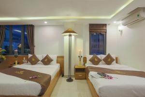 a hotel room with two beds and windows at Trang Ngan Hotel by THG in Danang
