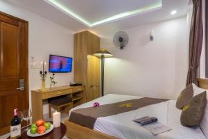a hotel room with a bed and a desk with a computer at Trang Ngan Hotel by THG in Danang