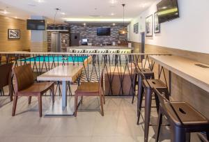 ein Restaurant mit Tischen und Stühlen und einem Pool in der Unterkunft Microtel Inn & Suites by Wyndham Culiacán in Culiacán Rosales