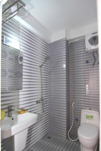 a bathroom with a toilet and a sink and a shower at Huong Cang Sea View Hotel in Cat Ba +44 photos
