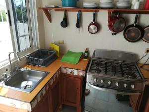 a kitchen with a sink and a stove at Casita Aurora in Chemuyil