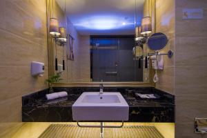 baño con lavabo y espejo grande en Zhongtian Mayfair Hotel - Bao'an International Airport Xixiang Subway Station, en Shenzhen