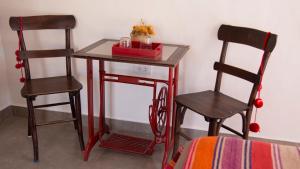 a small table with two chairs and a table with a box at Cabañas Cultura Tafi in Tafí del Valle