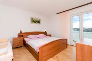 a bedroom with a bed and a large window at Apartment Stojna in Lopar