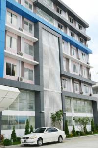 a white car parked in front of a building at Hotel Broadway Yangon in Yangon