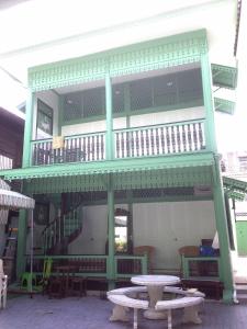 un edificio con balcone arredato con tavolo e tavoli di Green Teak House a Bangkok