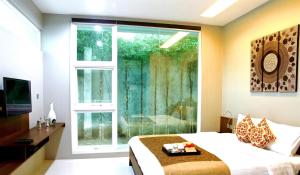 a bedroom with a bed and a large window at Ampera Avenue Residence in Jakarta