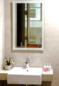 a bathroom with a white sink and a mirror at Ampera Avenue Residence in Jakarta