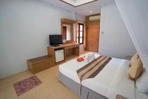 Tonsai Bay Resort في شاطئ تونساي: غرفة نوم بسرير كبير وتلفزيون