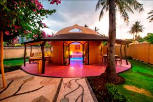 un cenador en un patio trasero con una palmera en Bel Air Resort en Gili Air