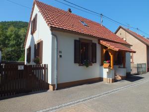 a small white house with a brown roof at Meublé Celtic in Niederbronn-les-Bains