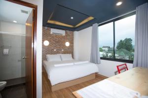 a bedroom with a bed and a bathroom with a window at Give Me 5 Hostel in Chiang Mai