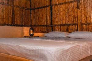 a bed with two pillows on it in a room at Sandy Edge in Kalpitiya