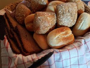 ein Korb mit Brot und Gebäck auf dem Tisch in der Unterkunft Pension Im Bett in Nürnberg
