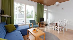 a living room with a blue couch and a table at Holiday Club Airisto Apartments in Strandby