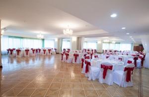 a banquet hall with white tables and red and white chairs at Grand Hotel Victory in Aktau +66 photos