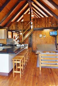 a kitchen with wooden counters and stools in a room at First Group Sodwana Bay Lodge Self Catering in Sodwana Bay