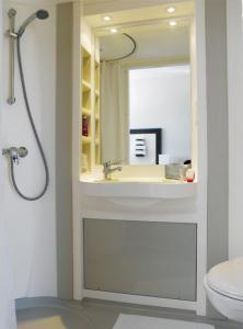 een badkamer met een wastafel en een spiegel bij Hôtel Akena City Albi Gaillac in Brens
