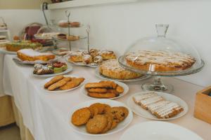 una tavola piena di diversi tipi di prodotti da forno e torte di Bellini Home B&B a Catania