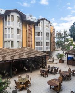 an outdoor patio with tables and chairs and buildings at Hotel Maharajah in Mamoudzou