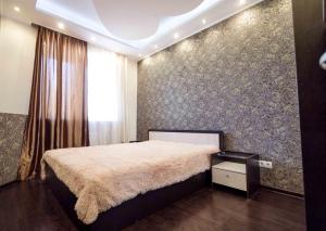 a bedroom with a large bed and a wall at Gazovikov 33 Akvapark Evropeyskiy in Tyumen