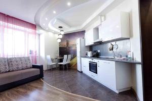 a kitchen and living room with a couch and a table at Gazovikov 33 Akvapark Evropeyskiy in Tyumen