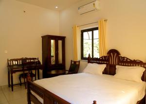 a bedroom with a bed and a window and a desk at Hotel Green Heaven Resort in Pushkar