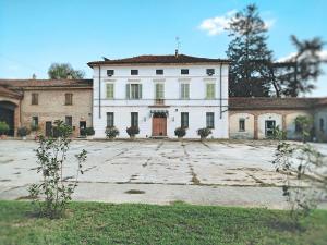 una grande casa bianca con un ampio cortile di Agriturismo Cascina Nuova a Cremona